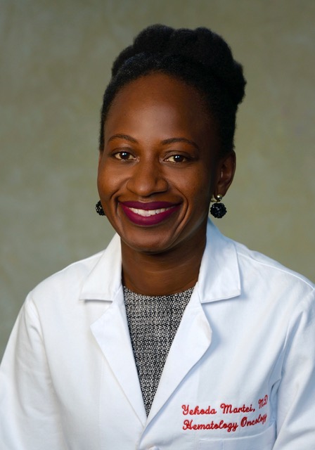 Yeshoda Martei - headshot of Black woman with white lab coat and dark colored top.