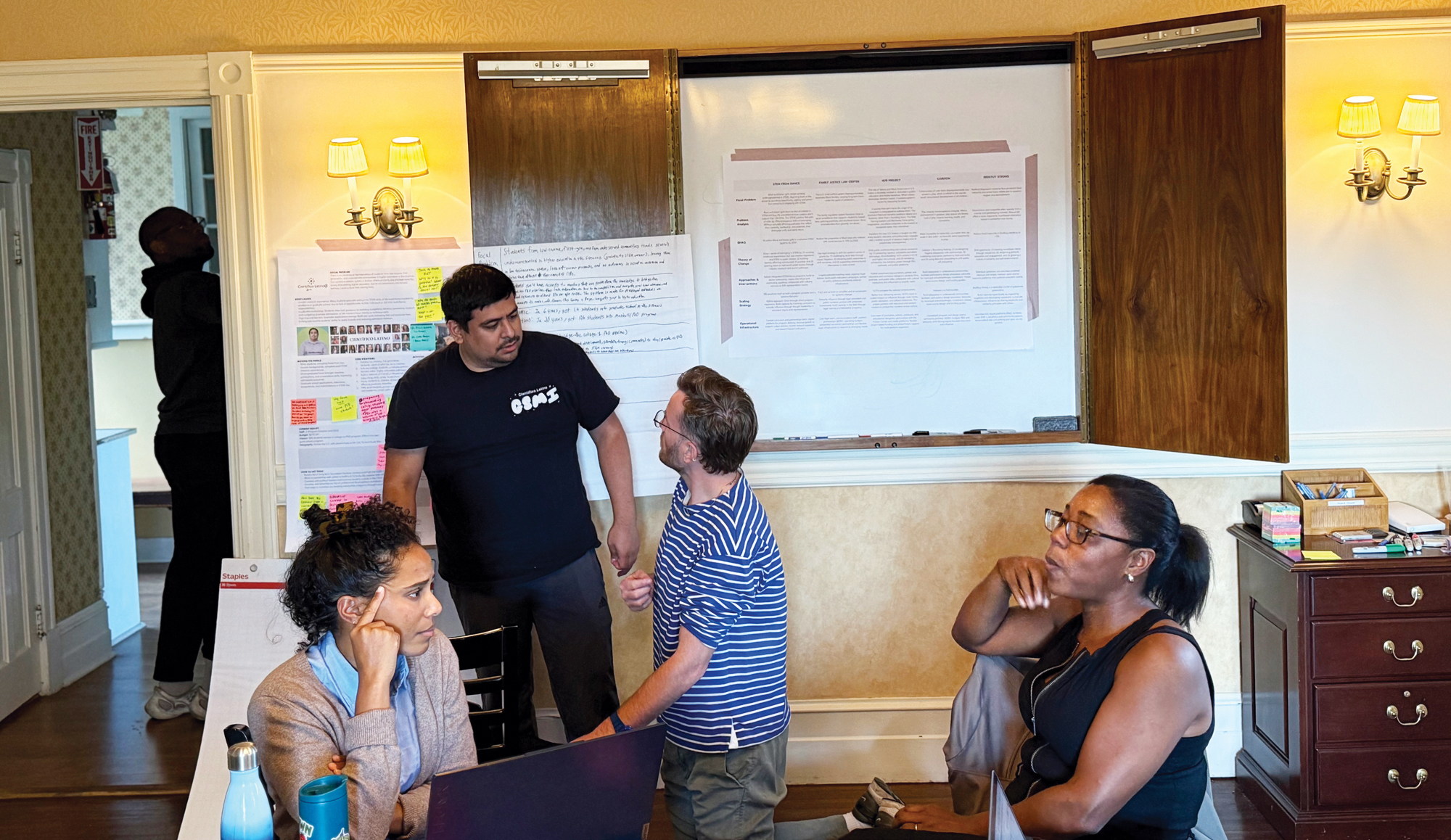 A photo of four people in a meeting.