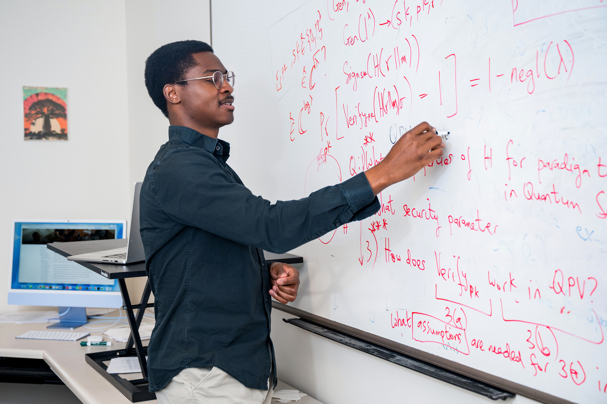 Photo of Dr. Alabi writing on a whiteboard.