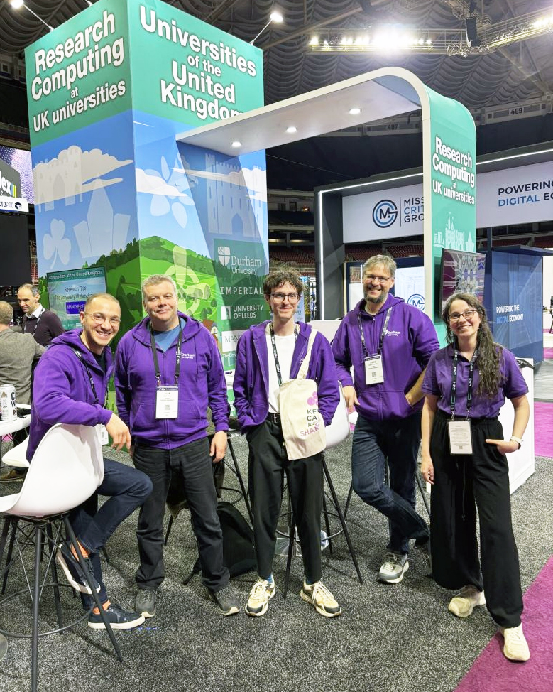 A photo of Gokberk Kabacaoglu with colleagues at a conference booth.
