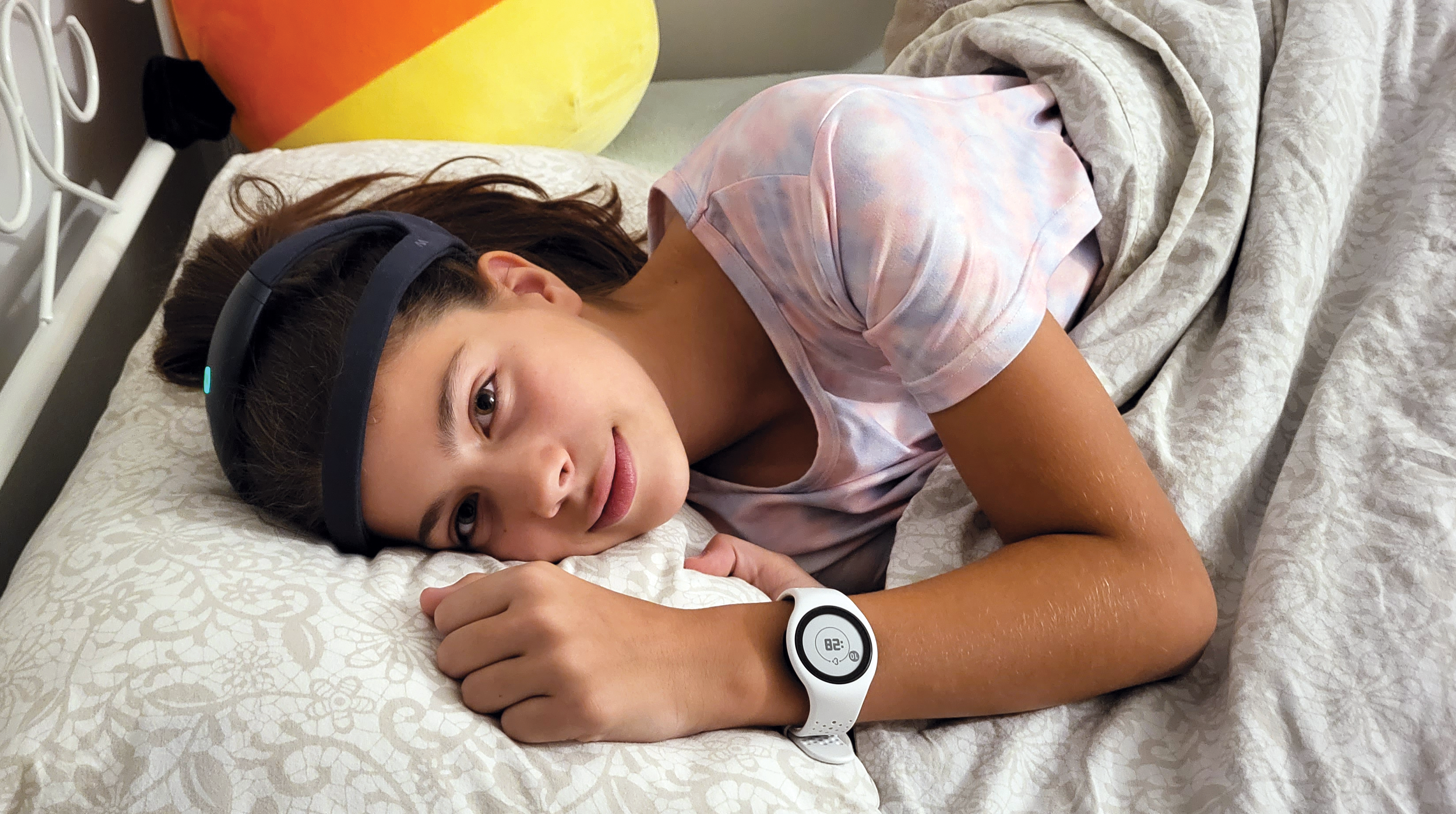 A young girl dressed in pajamas wearing a headband and watch.