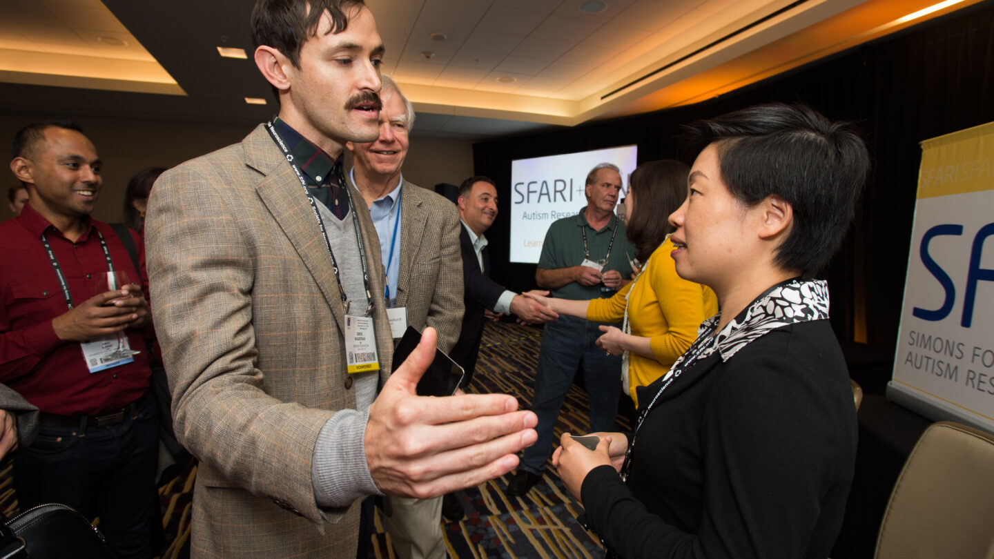 Woman and man talking as someone stands behind the man and watches