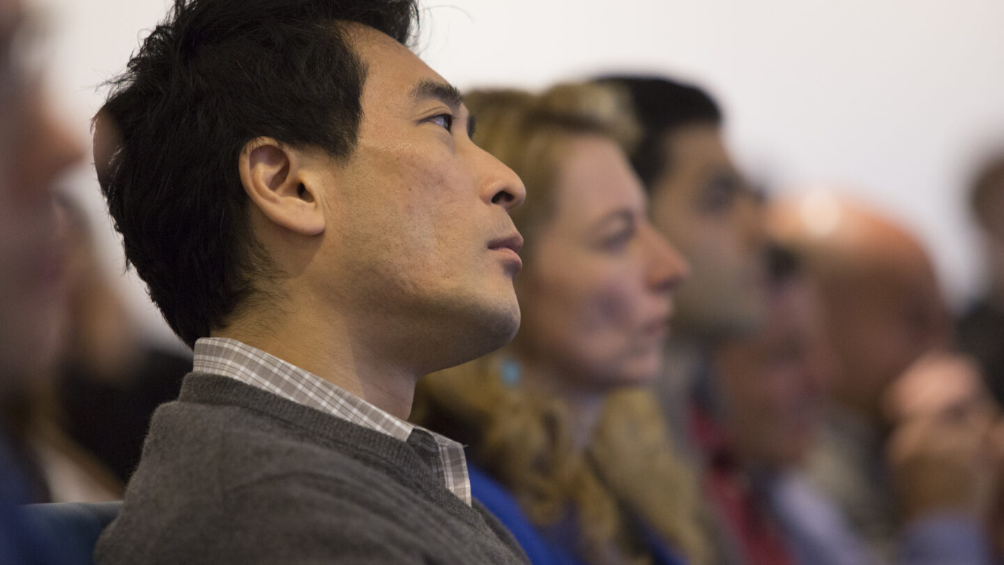 Man sitting in lecture hall row of people