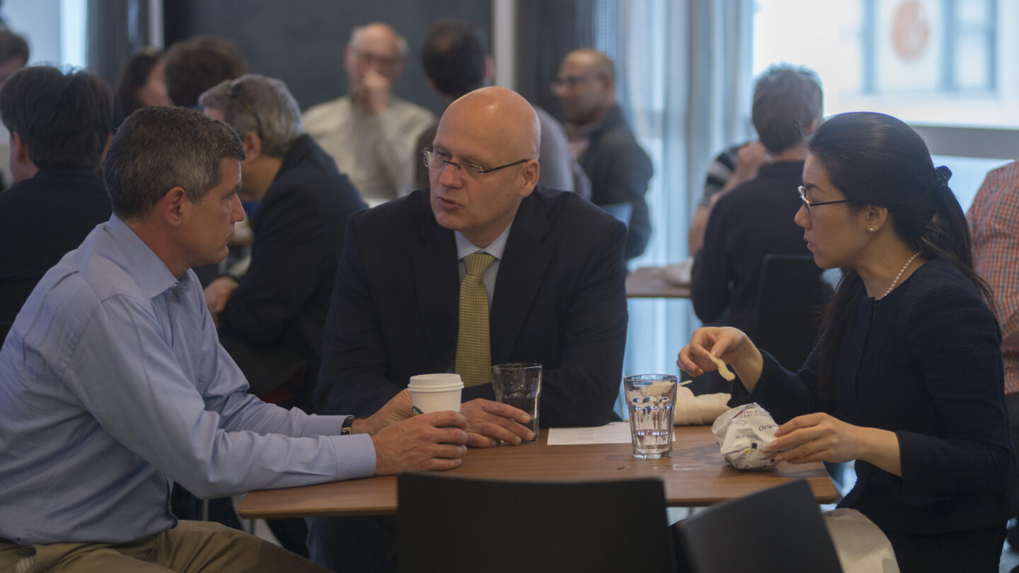 Three people sitting at a table and talking