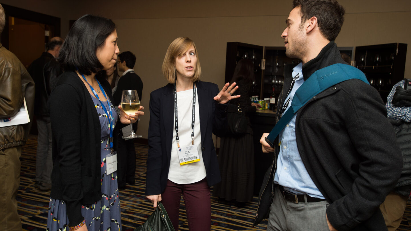 Three people standing and talking