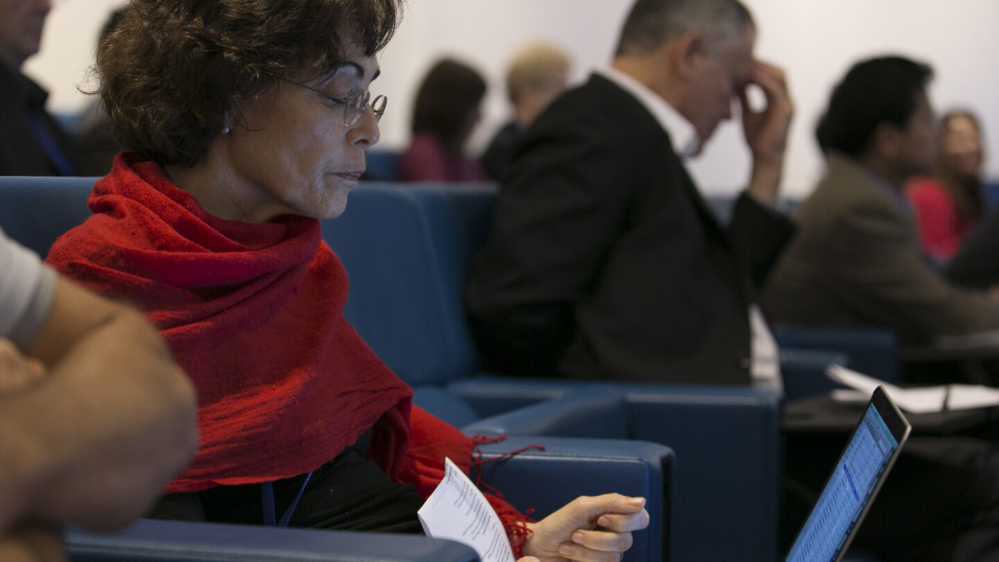 Woman sitting in a lecture hall while on her laptop