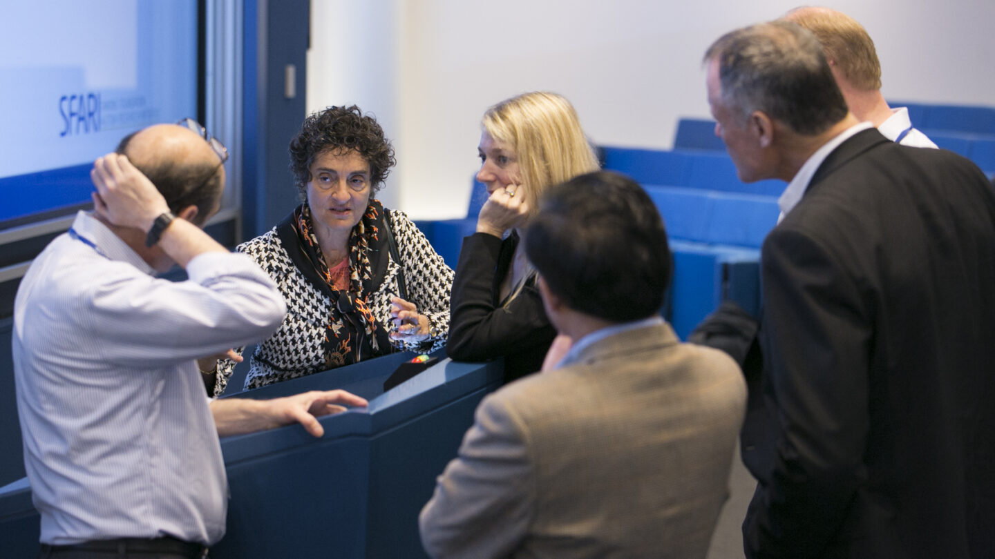 Six people standing around a lectern together