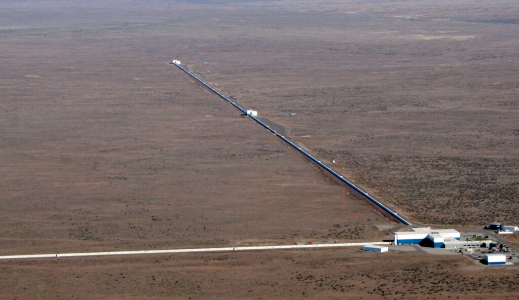 An aerial view of one of the LIGO laboratories. Two long, narrow buildings extend from a central hub.