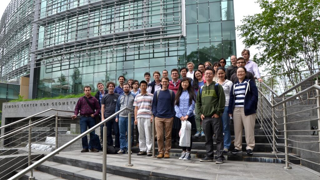 Group of people posing on steps outside the Simons Center for Geometry