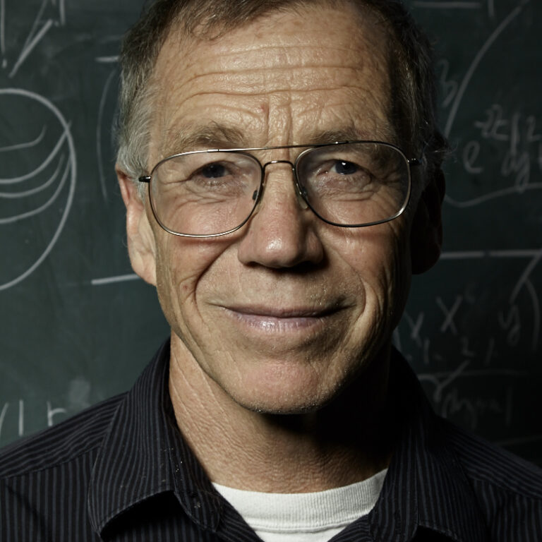 Mike Freedman in front of a chalkboard with math on it