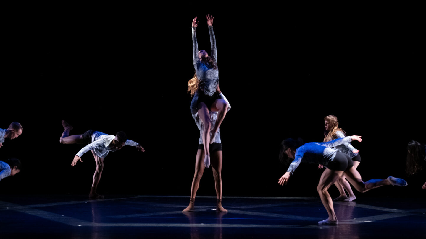 A photograph of multiple people engaged in a dance performance.