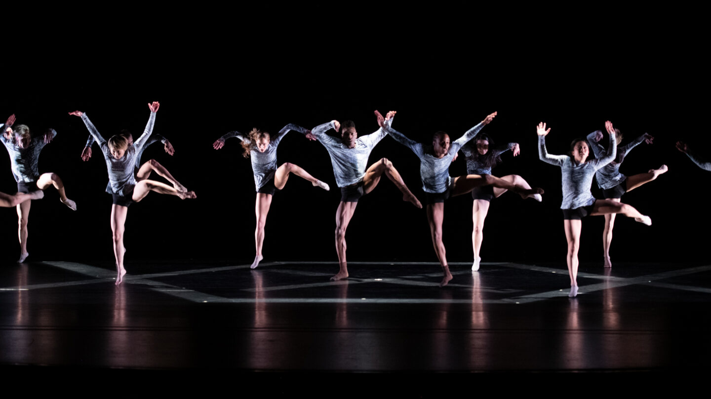 A photograph of multiple people engaged in a dance performance.