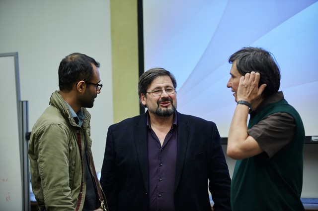 Three men standing and talking