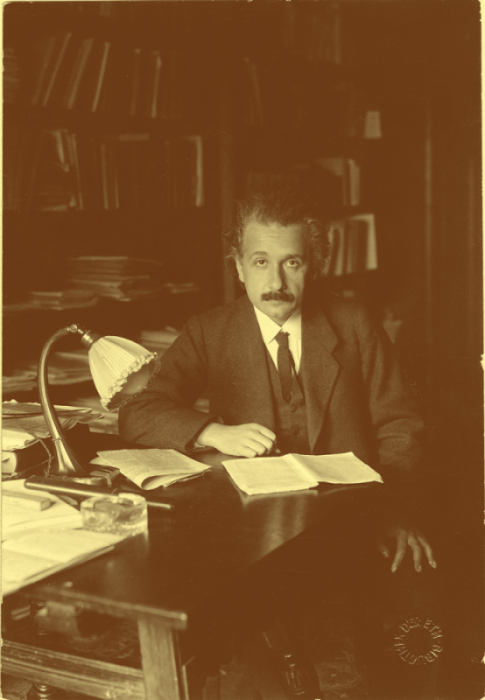 Albert Einstein sitting at a table