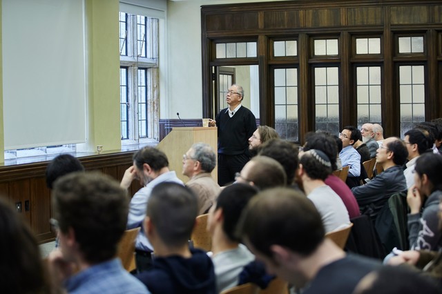 Man standing by a lectern in front of a classroom of people