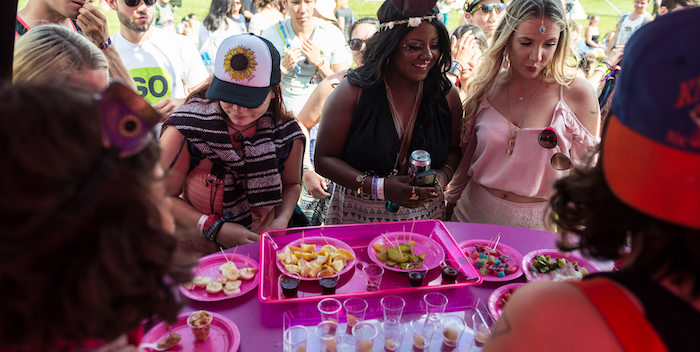 Women gathering around a table of food and drink samples