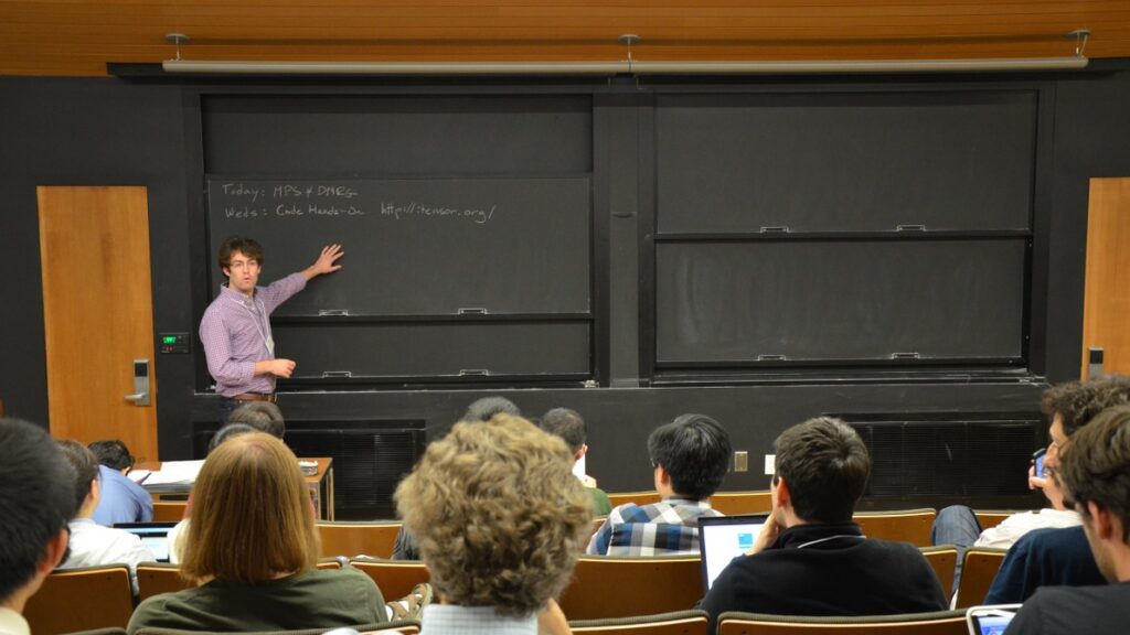 Man pointing to a sliding chalkboard