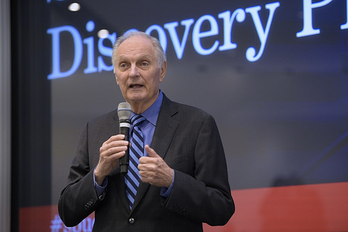 Man standing on a stage and speaking into a microphone