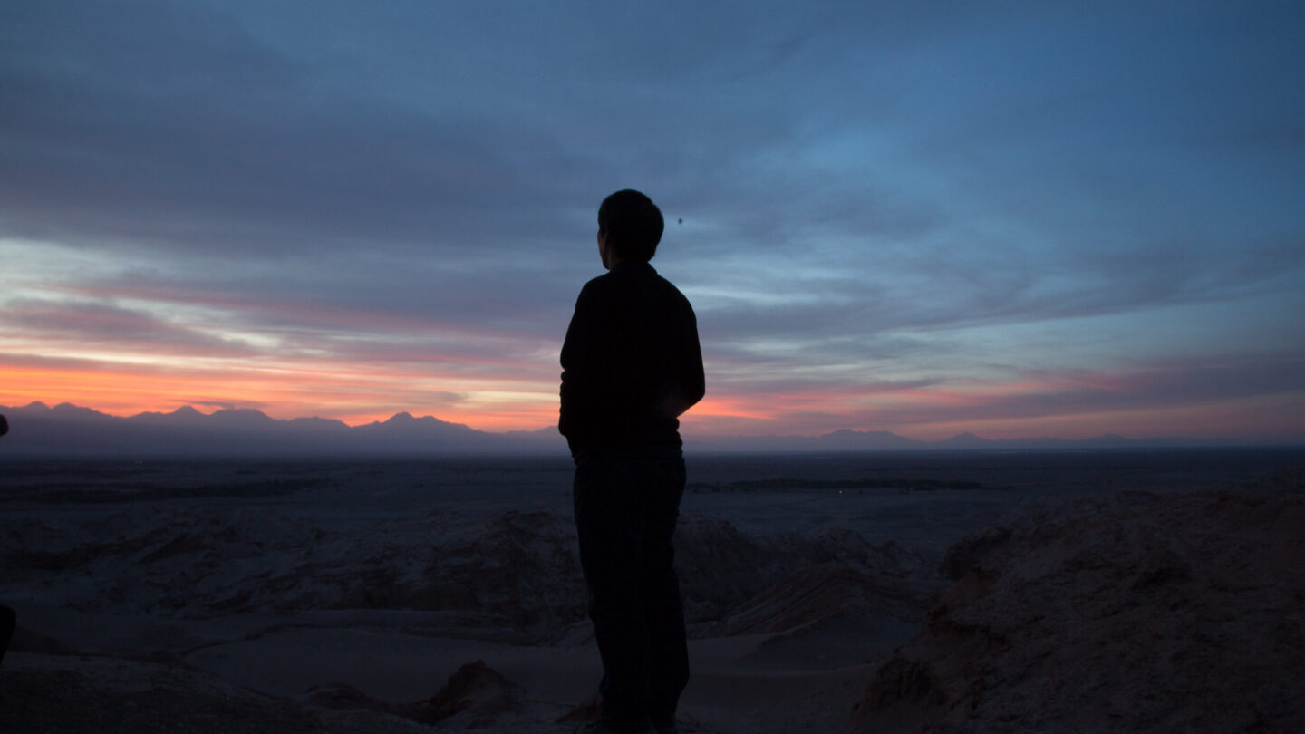 Man silhouetted by the sunset in the background