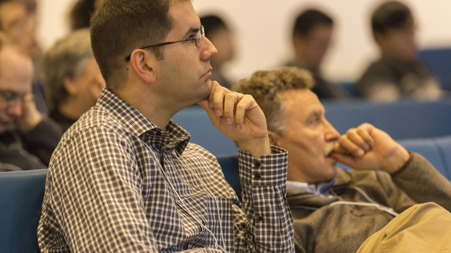 Two men sitting next to each other in a lecture hall