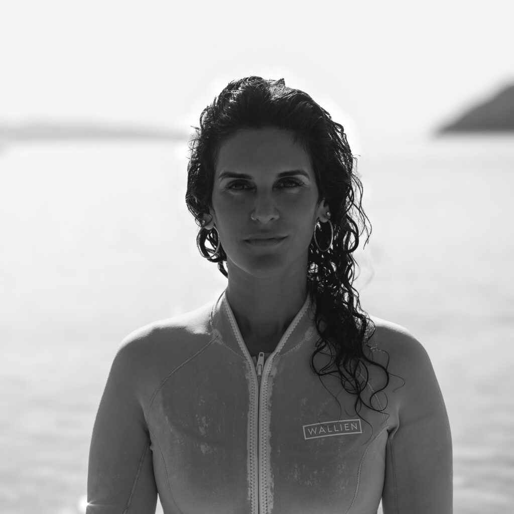 Marine biologist Diva Amon wearing a wet suit and standing by the water