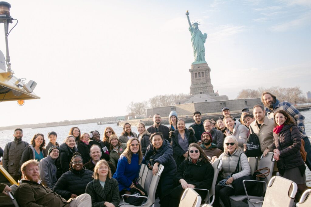Attendees pose in front of Statue of Liberty