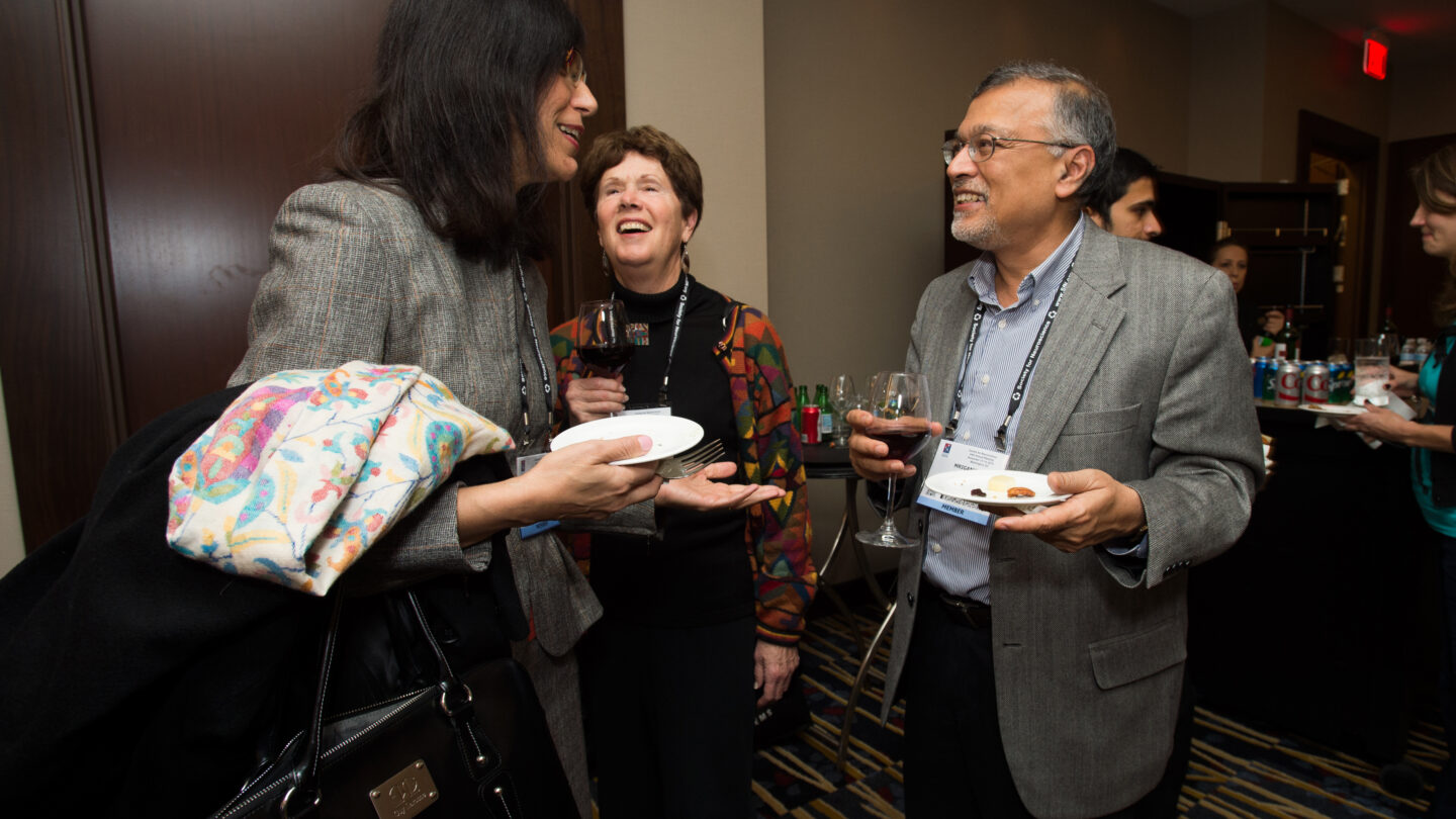 Three people standing and laughing together