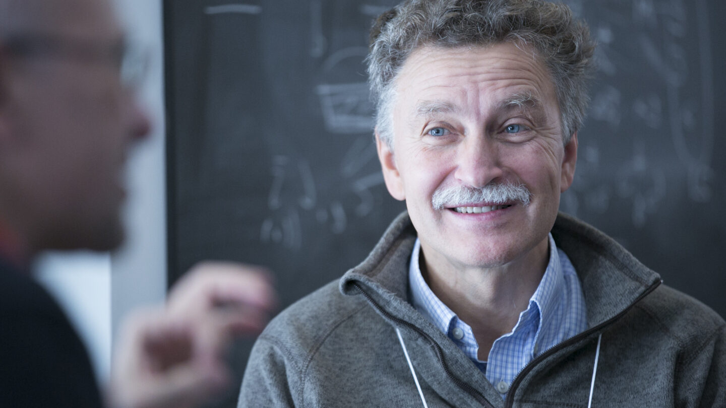 Man sitting in front of a blackboard