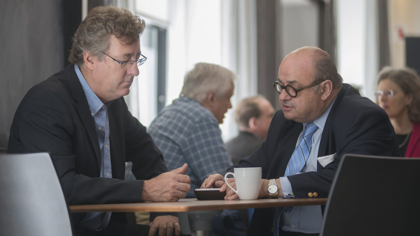 Two men sitting at a table and talking