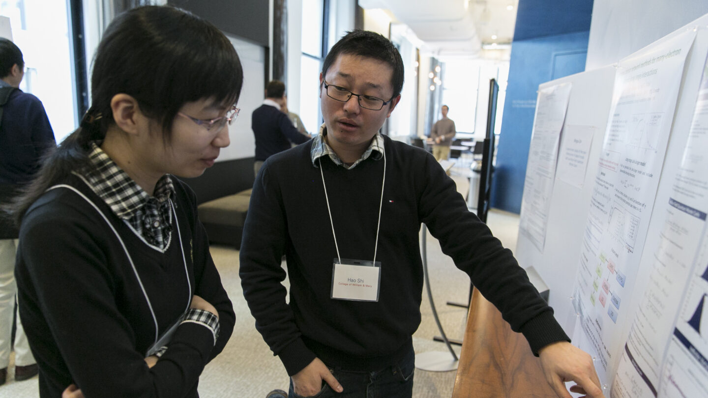Person pointing to a presentation as someone watches