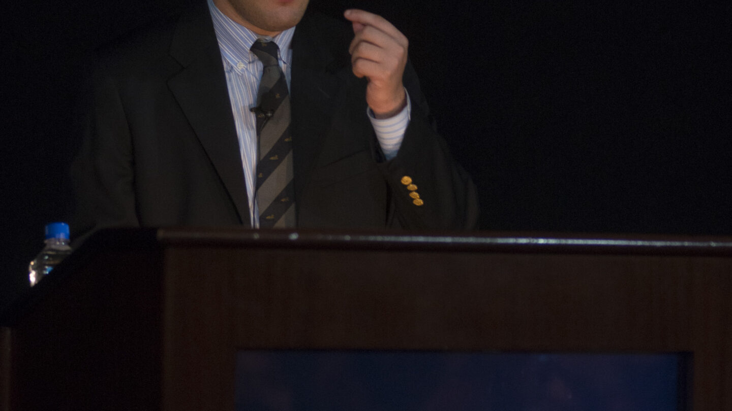 Man standing behind a lectern that says SFARI Simons Foundation Autism Research Initiative