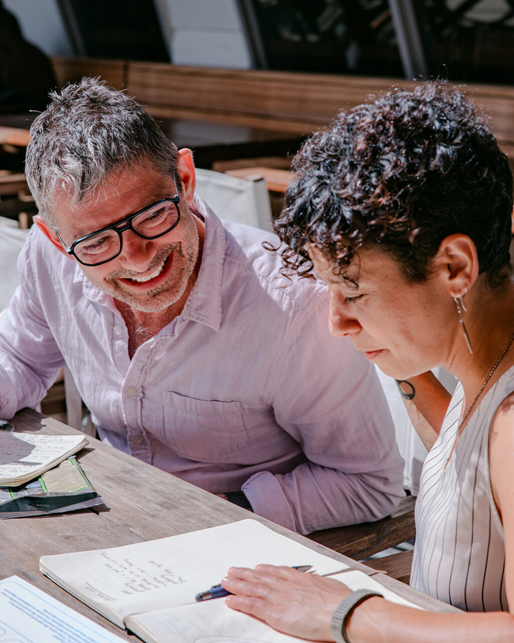 A photo of two people talking and writing.