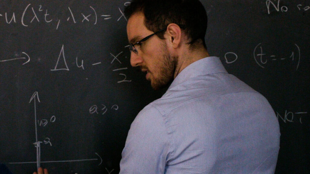 Alessio Figalli writing math on a chalkboard