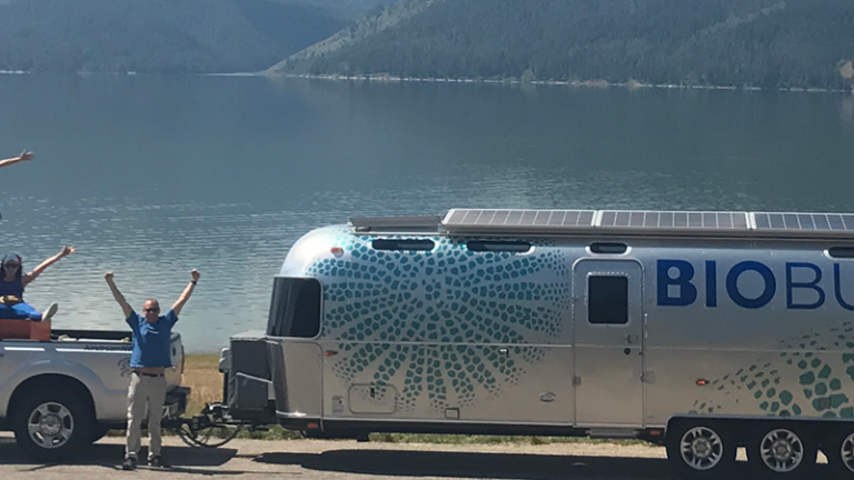 BioBus parked by water with people posing around it
