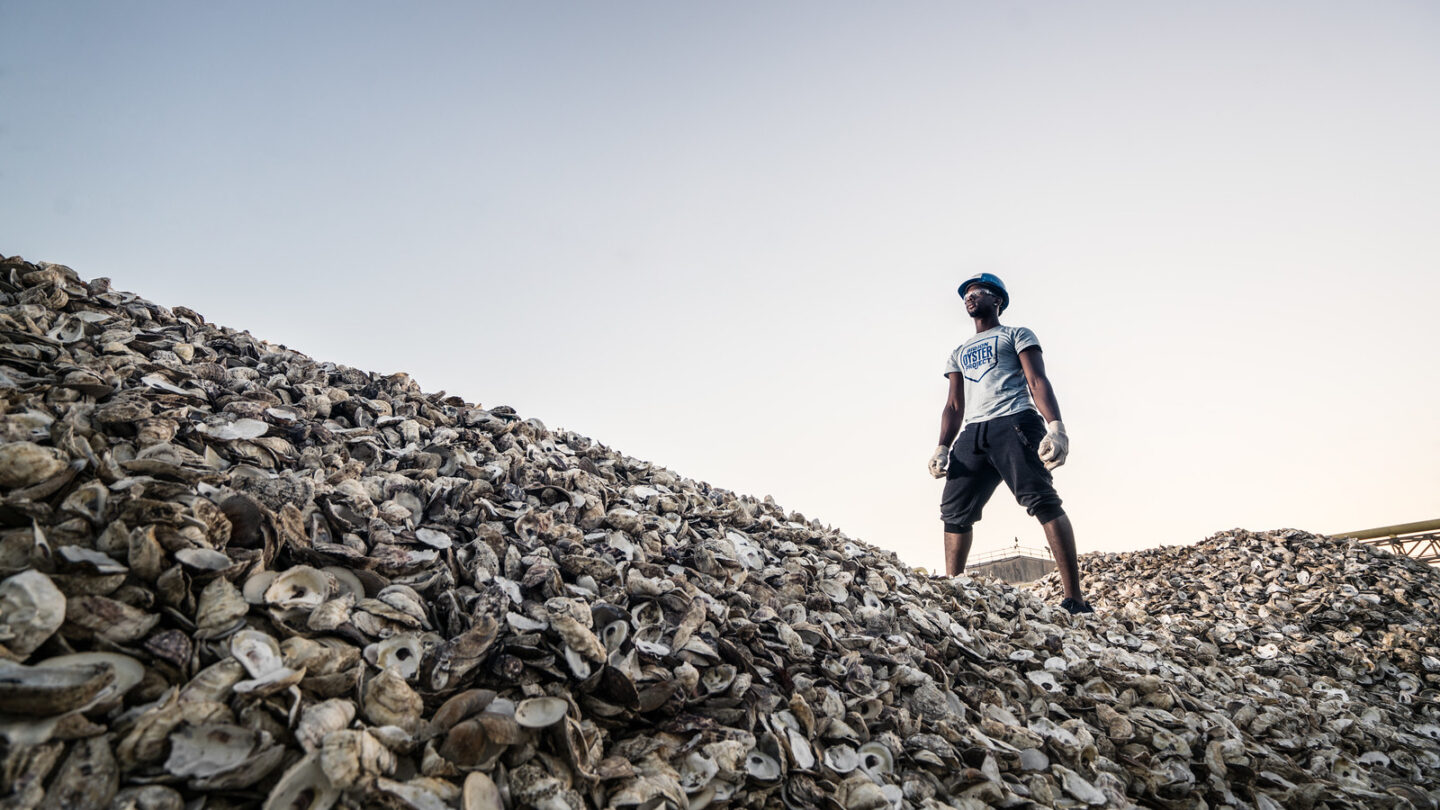 A man standing on hills made of empty oyster shells