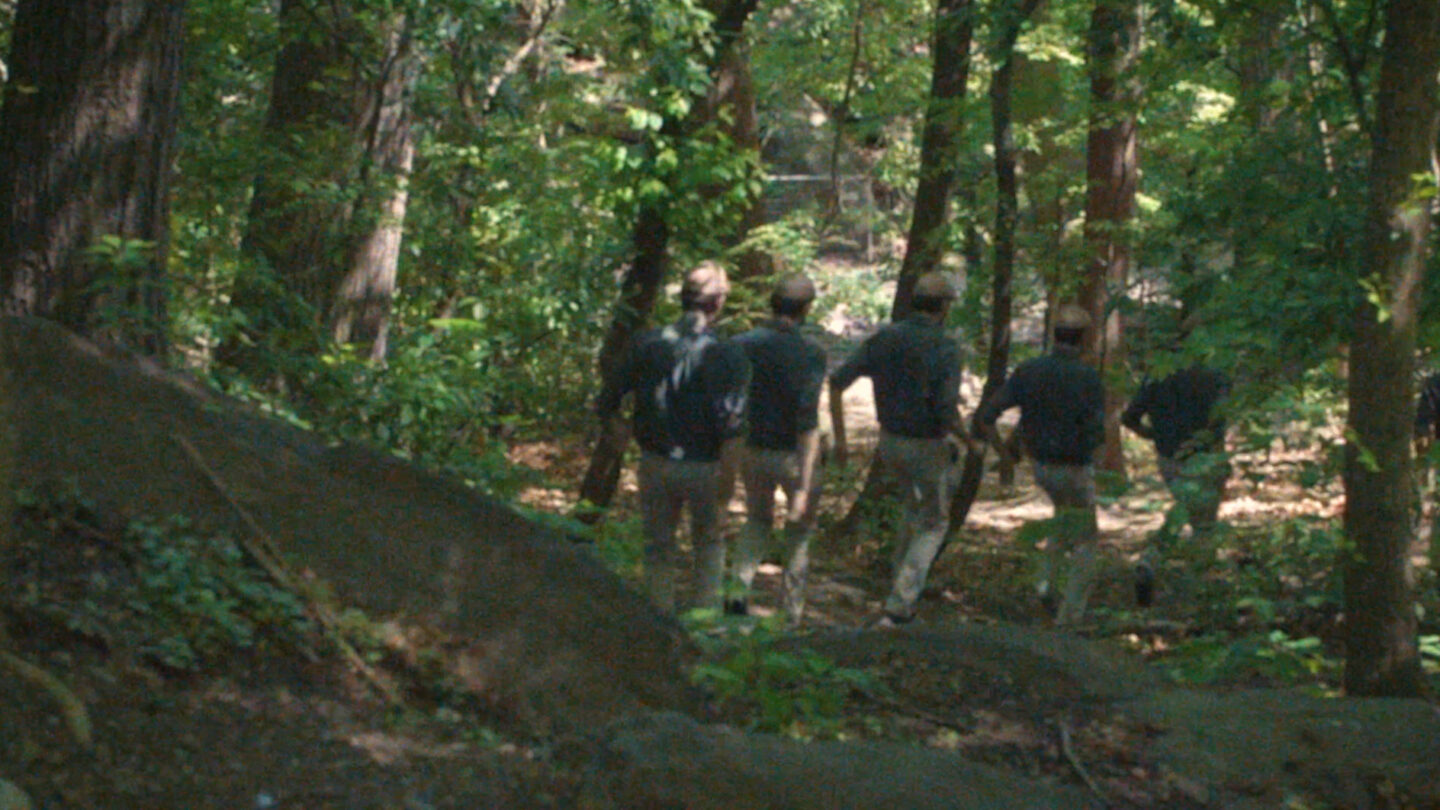 Many copies of the same man running down a hill.
