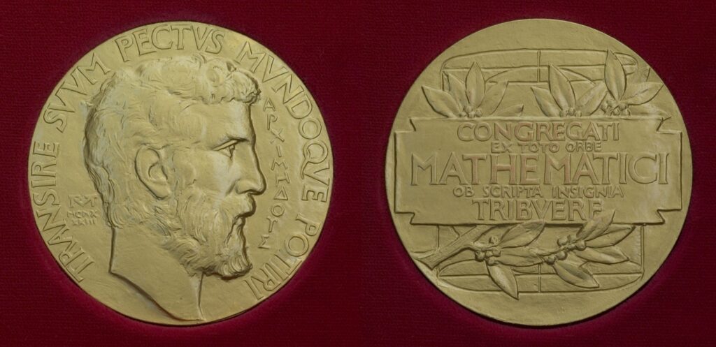 Two gold medals featuring engravings; the front shows a bearded mans profile with Latin text, and the back displays a rectangular panel with more Latin text and laurel branches, set against a dark red background.