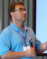 Fred Rasio wearing a hanging name tag while holding a microphone