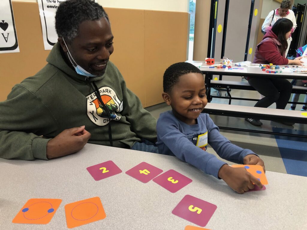 father and son playing with numbered cards