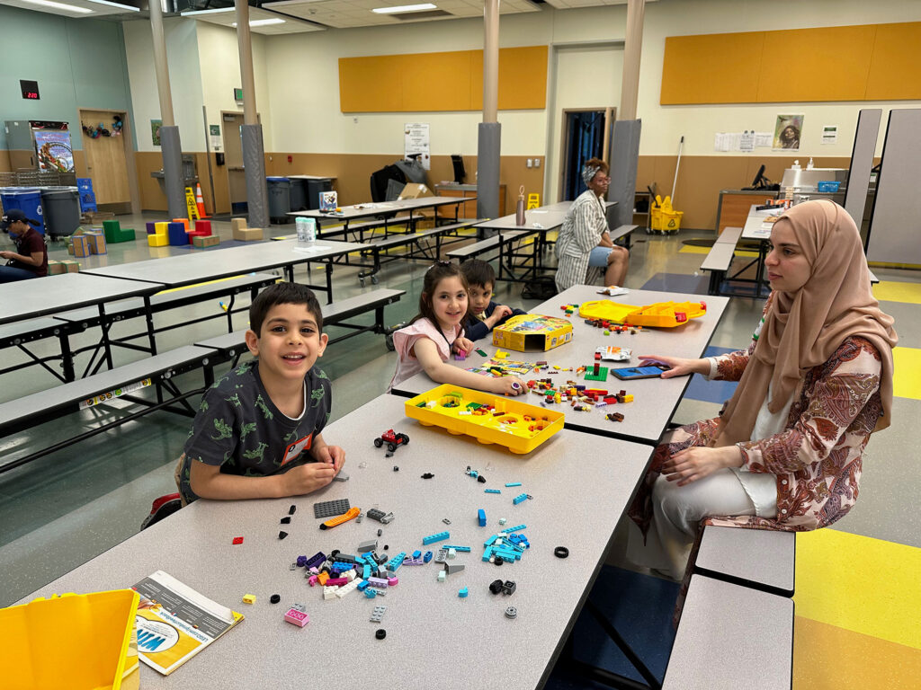 family playing with blocks at long table