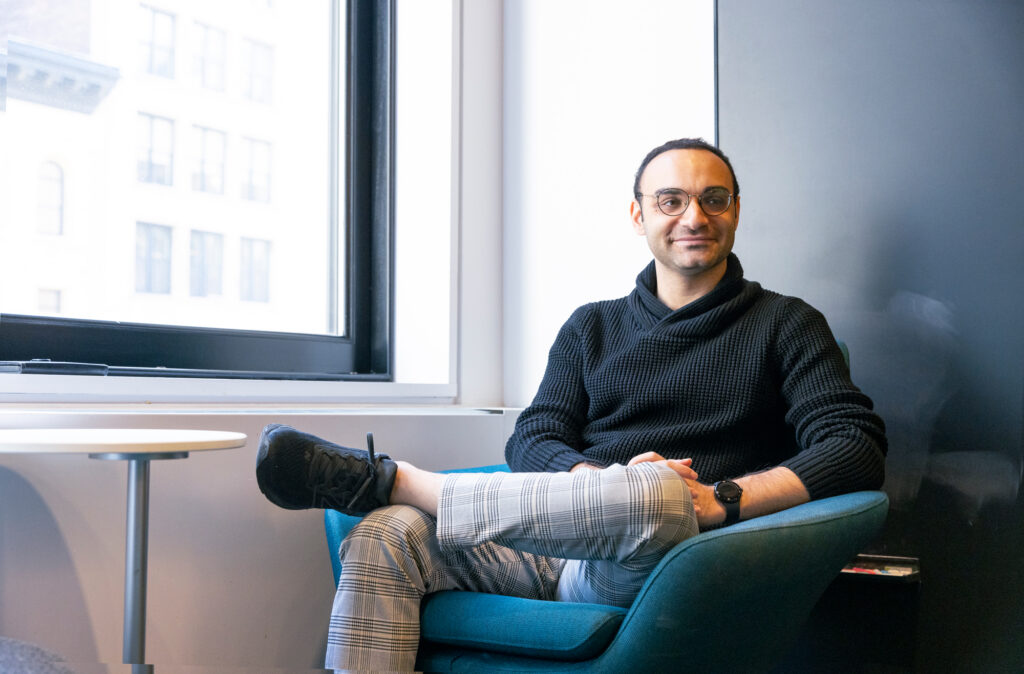 Adrian Bayer sitting in a chat by the window of the Simons Foundation office.