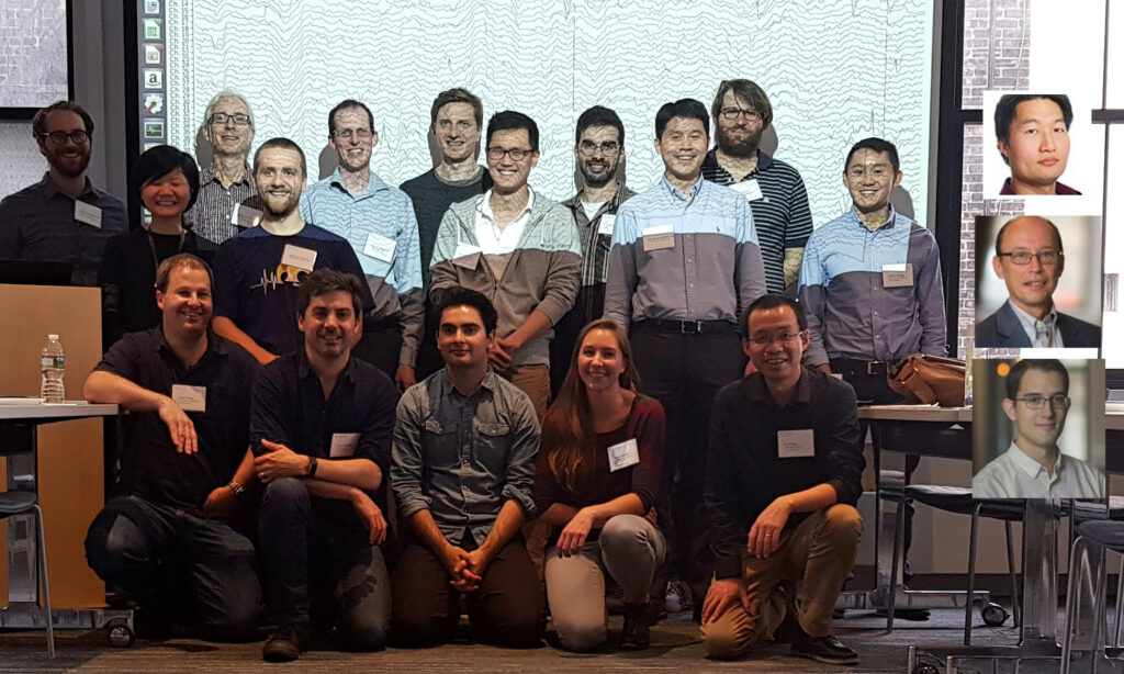 Group of people posing for a photo in front of a projector. Three people's photos are photoshopped on to the right side of the picture