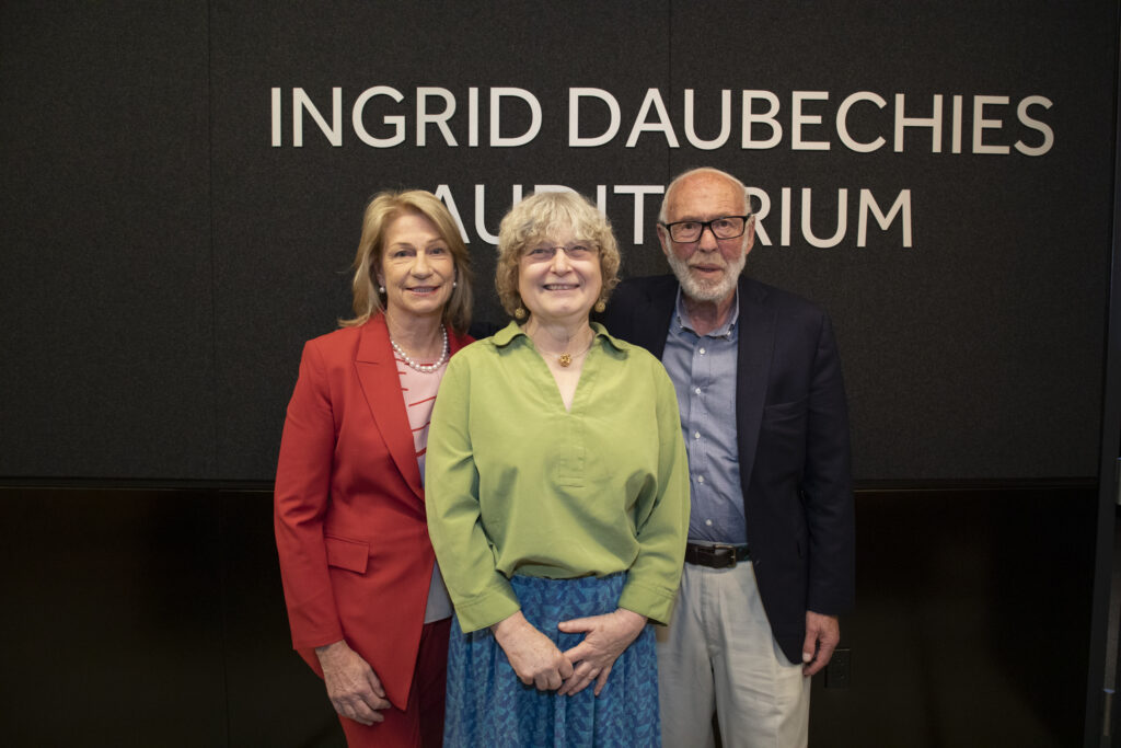 Marilyn Simons, Ingrid Daubechies, Jim Simons in front of new auditorium sign