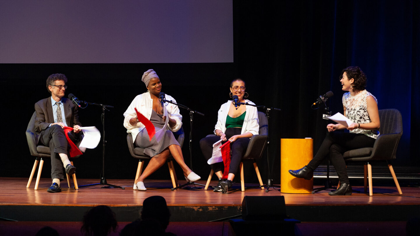 Four people sitting on individual couches on a stage