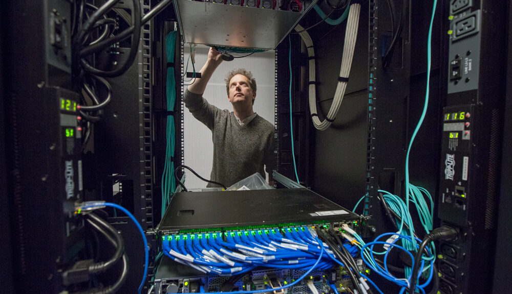 Ian Fisk reaching up to some wires