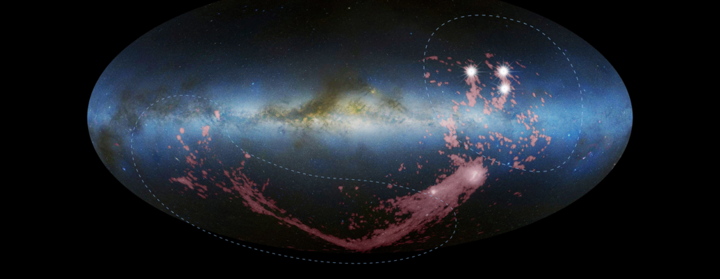 A photo mosaic of an edge-on view of the Milky Way galaxy, looking toward the central bulge. The arc-shaped Magellanic Stream stretches below the galaxy’s plane and the shredded, fragmented Leading Arm crosses the galaxy’s plane and extends above it