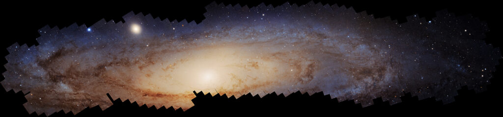 A detailed, stitched image of a spiral galaxy with a bright central core, surrounded by swirling arms and countless stars on a dark background.