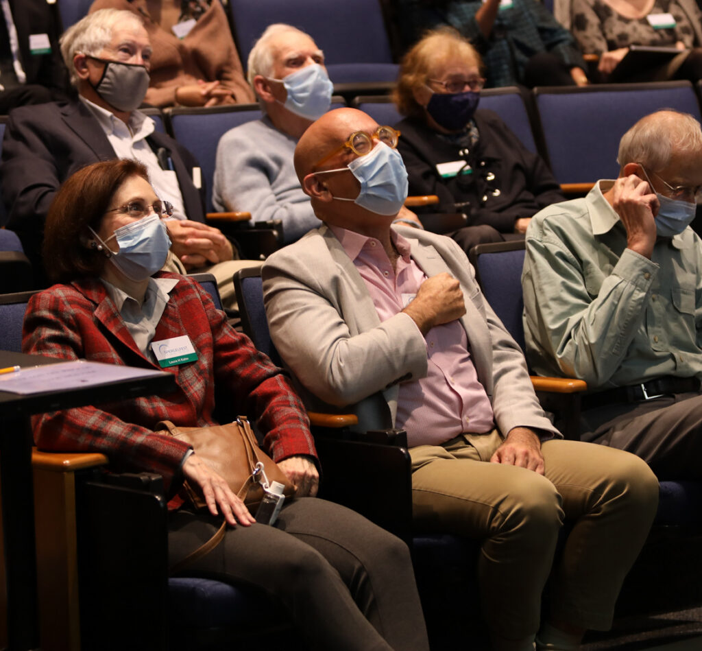 A photograph of David Spergel amongst other people in seats in an auditorium.