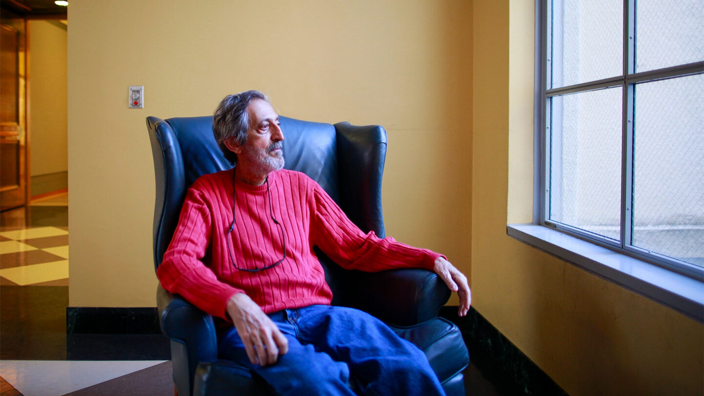 Avi Wigderson sits in a chair in the library at the University of California, Berkeley.