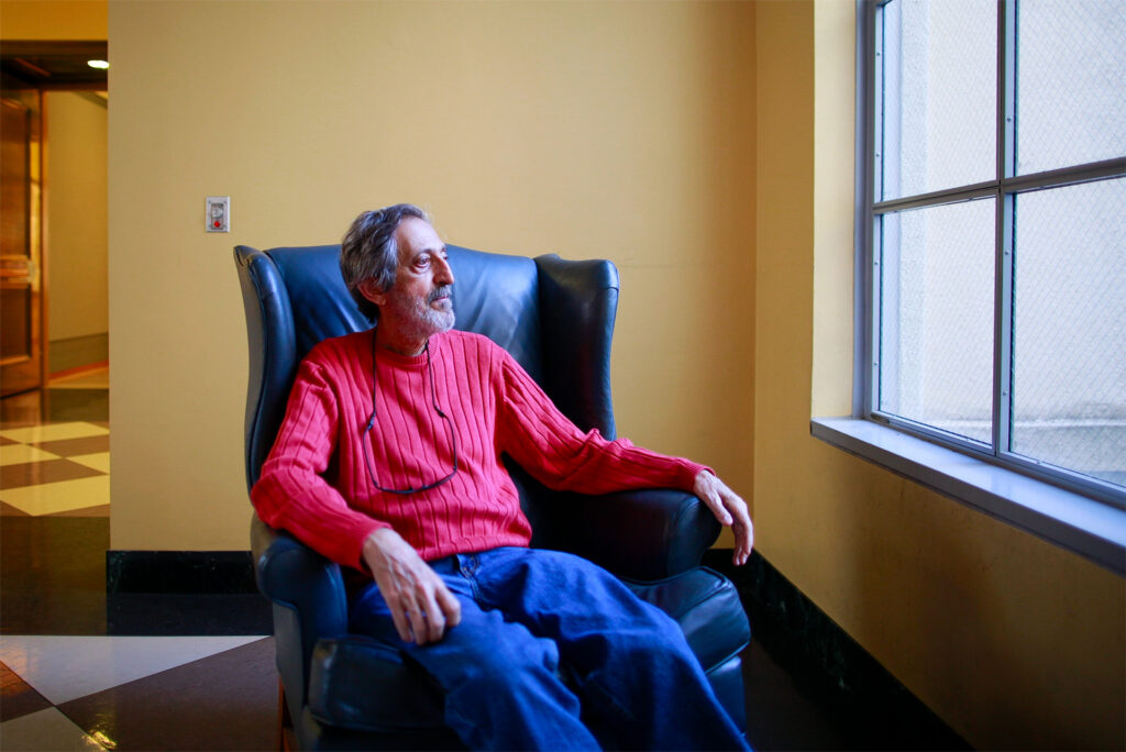 Avi Wigderson sits in a chair in the library at the University of California, Berkeley.